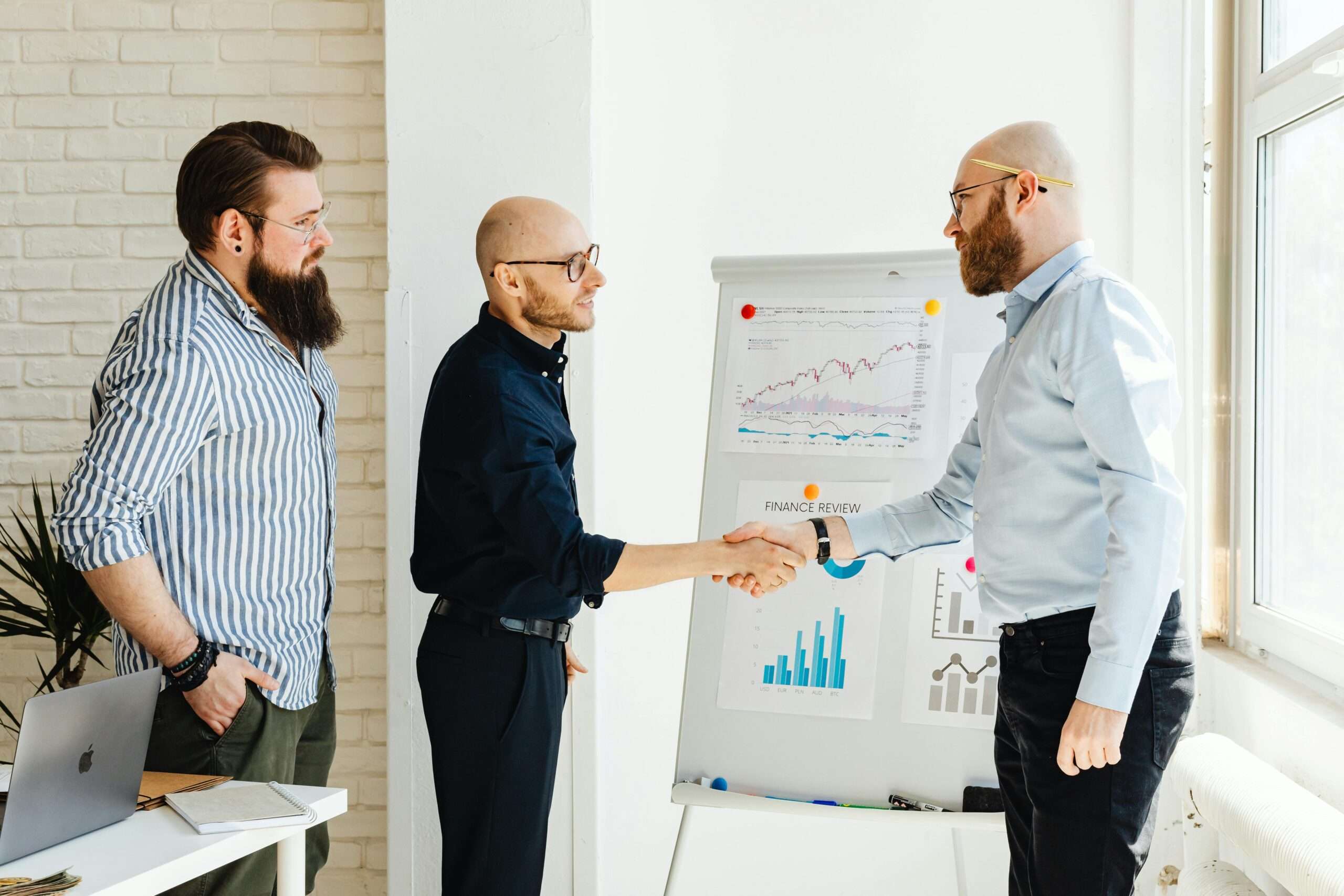Three business colleagues engage in a productive meeting, exchanging ideas with data charts.